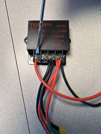 A black box with red and black wires

AI-generated content may be incorrect.