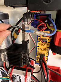 A hand holding a black and red electrical device

AI-generated content may be incorrect.