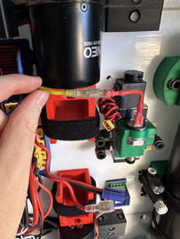 A hand holding a black cylinder with red and blue wires

AI-generated content may be incorrect.