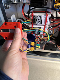 A hand holding a device with wires

AI-generated content may be incorrect.