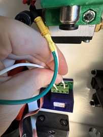 A hand holding a green and white wire

AI-generated content may be incorrect.