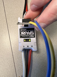 A hand holding a small device with wires

AI-generated content may be incorrect.