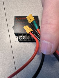 A hand holding wires to a device

AI-generated content may be incorrect.
