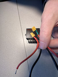 A hand holding wires to a device

AI-generated content may be incorrect.