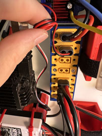 A person connecting wires to a device

AI-generated content may be incorrect.